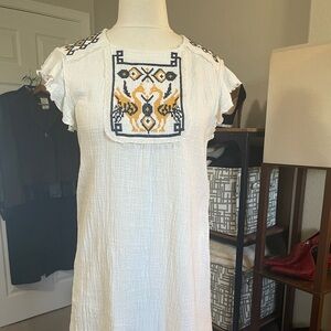 White cotton gauzy knee length dress with lace and embroidery. Flutter sleeve